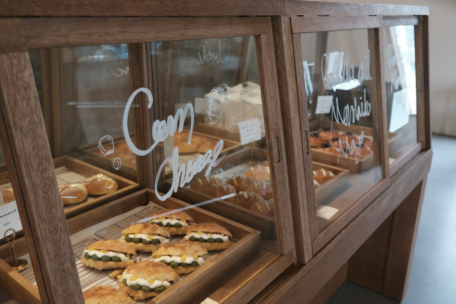 Vitrina de madera con sándwiches y facturas